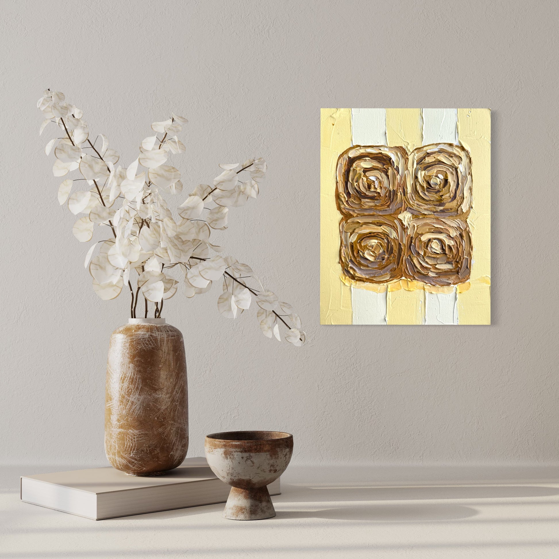 Decorative scene with a vase of flowers, small bowl, and abstract painting on a wall.