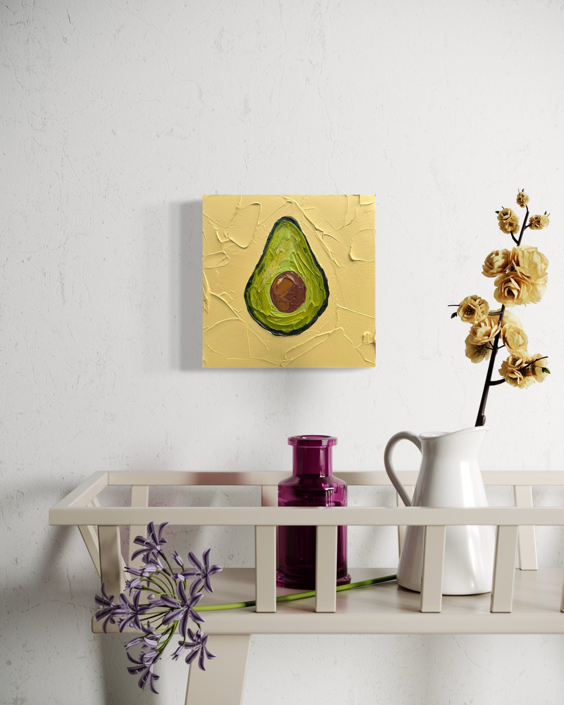 Avocado painting on a wall above a shelf with decorative items.