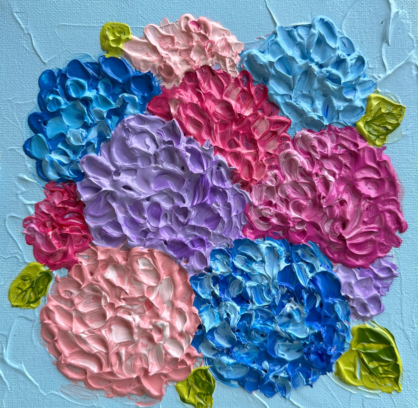 Colorful floral arrangement with pink, blue, and purple flowers on a textured light blue background.
