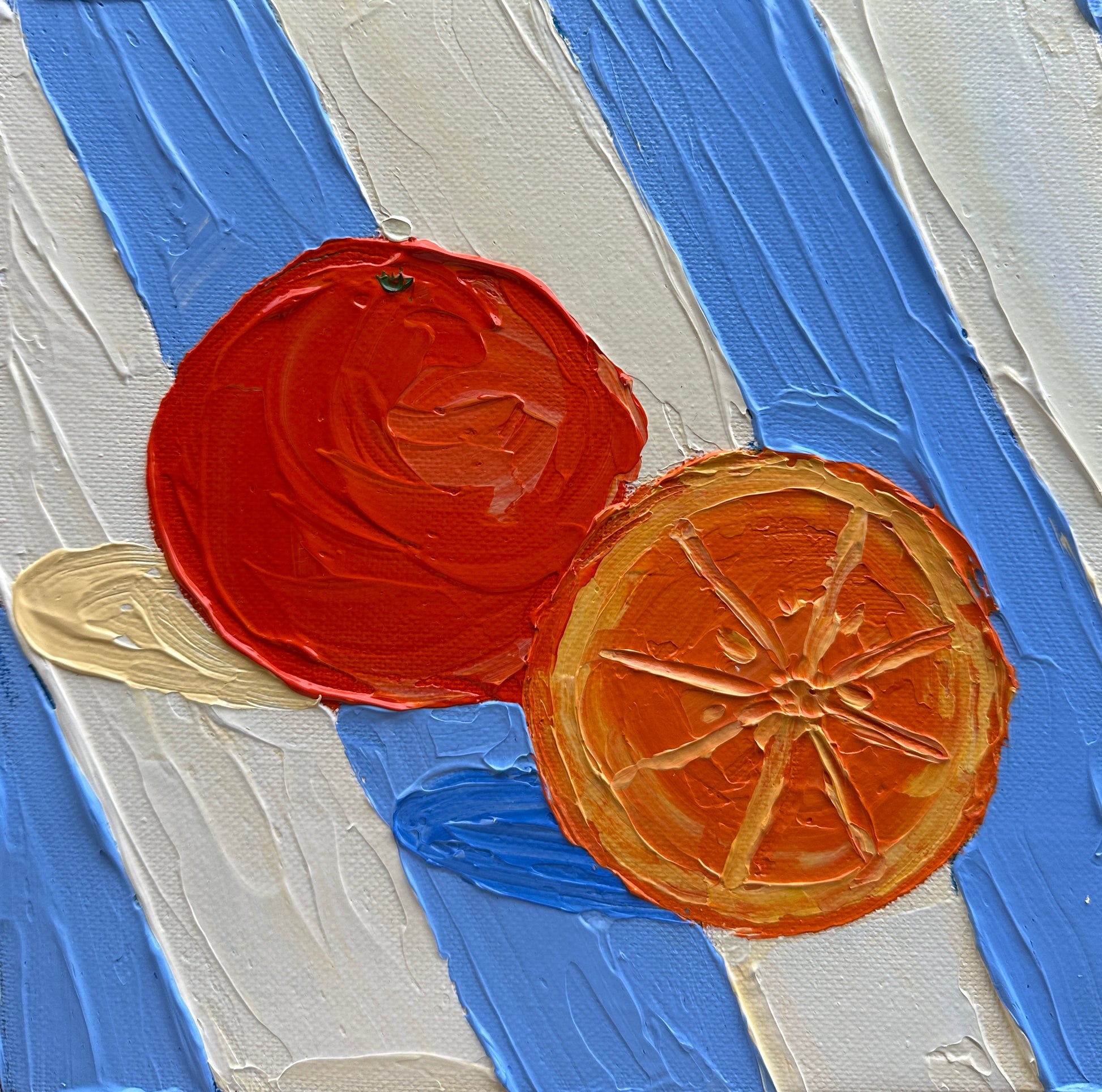 Two painted orange slices on a textured blue, cream, and beige background