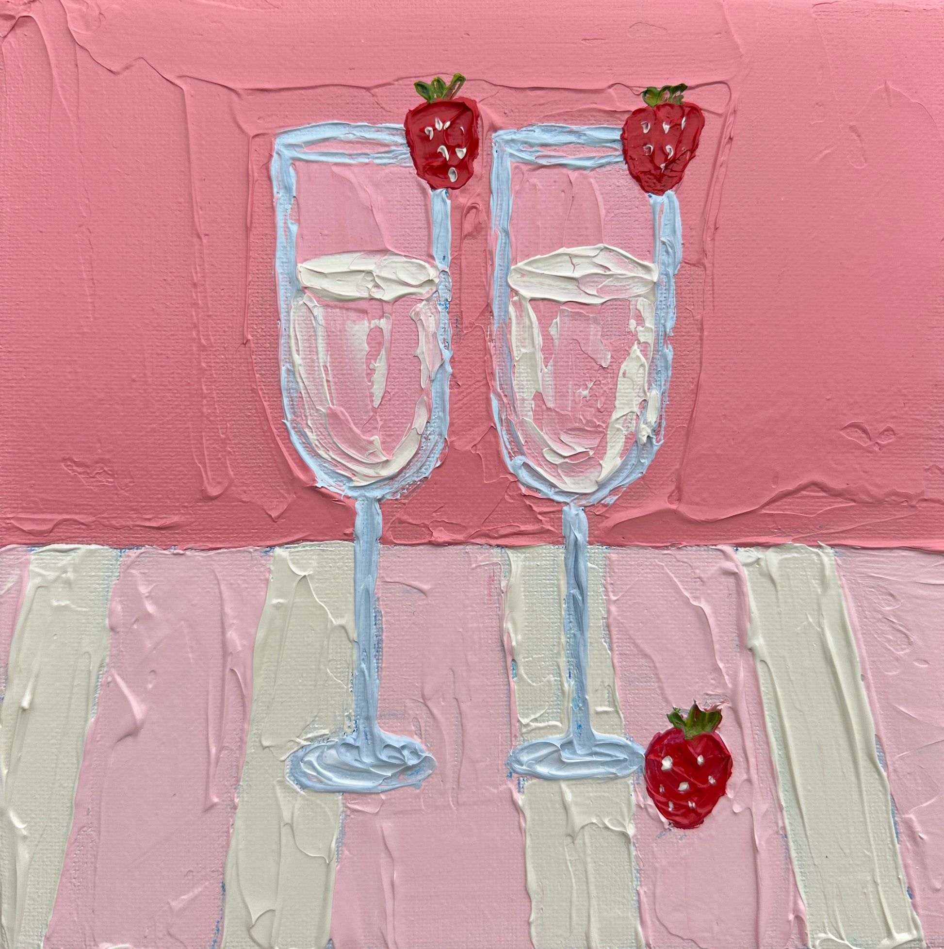 Two champagne glasses with strawberries on a pink and white striped background