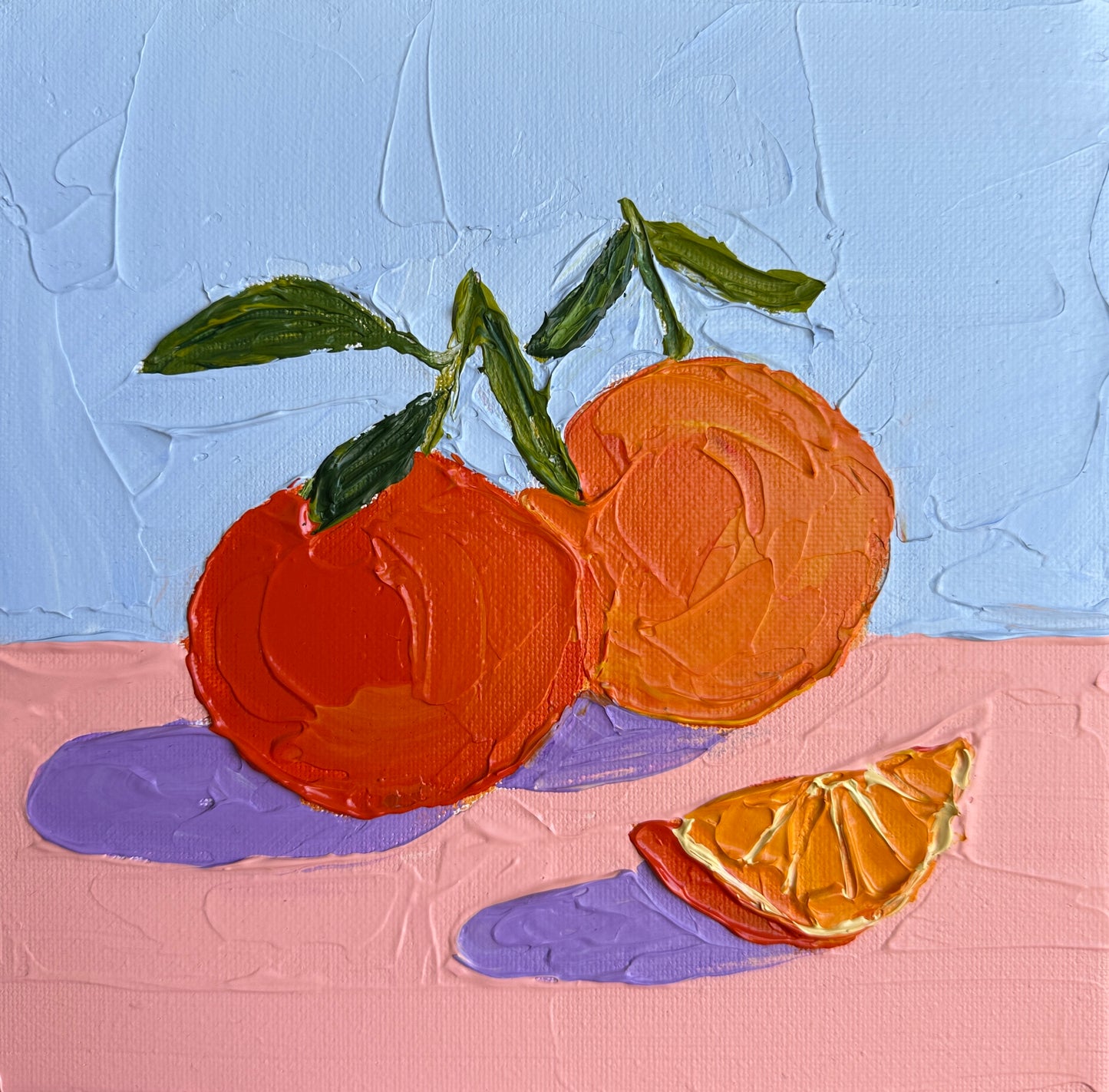 Painting of oranges with a slice on a textured blue and pink background