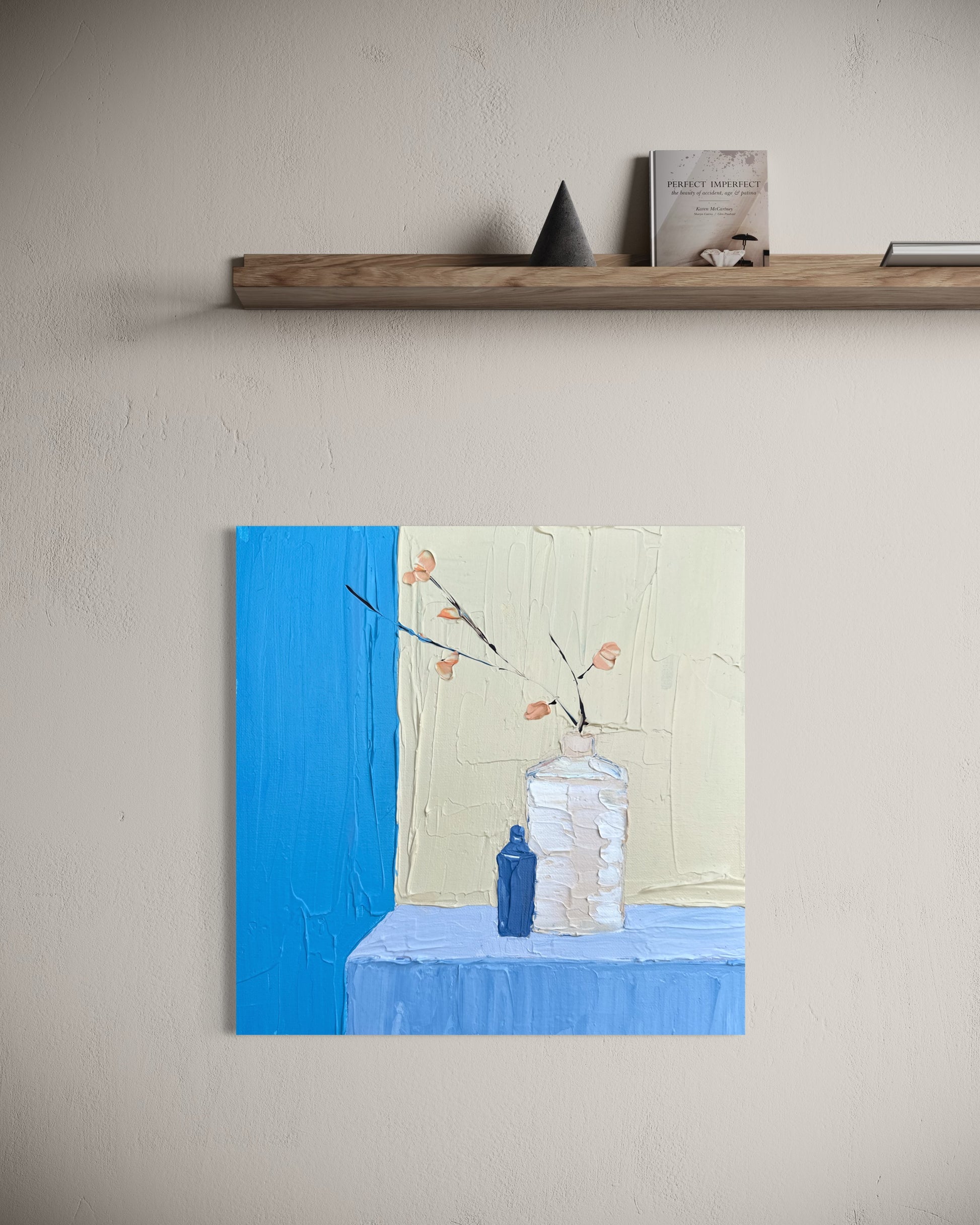 Small abstract painting on a wall with a shelf above it