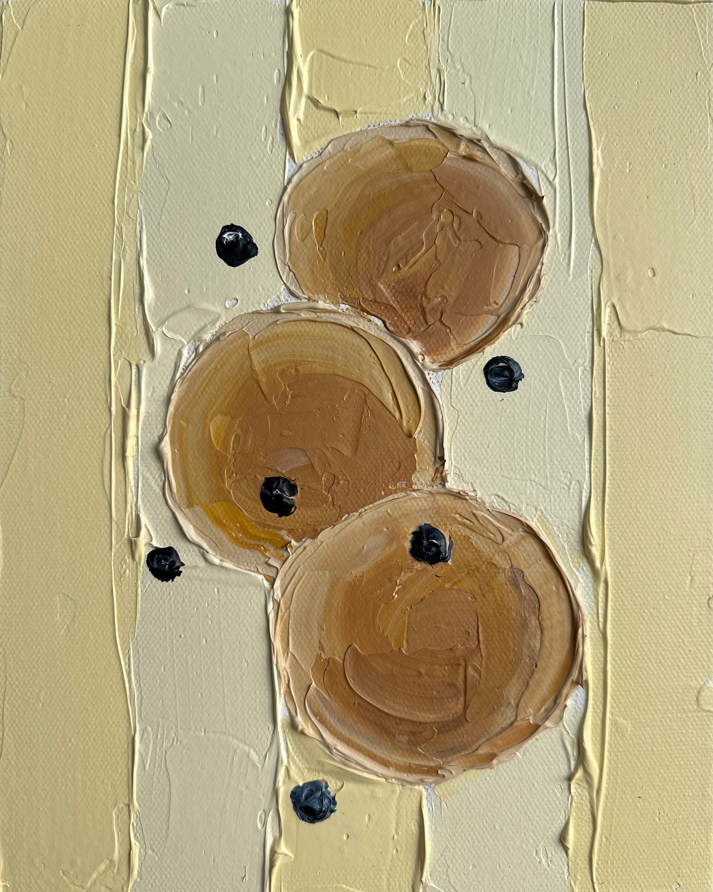 Close-up of beige paint swatches with black dots on a textured beige background