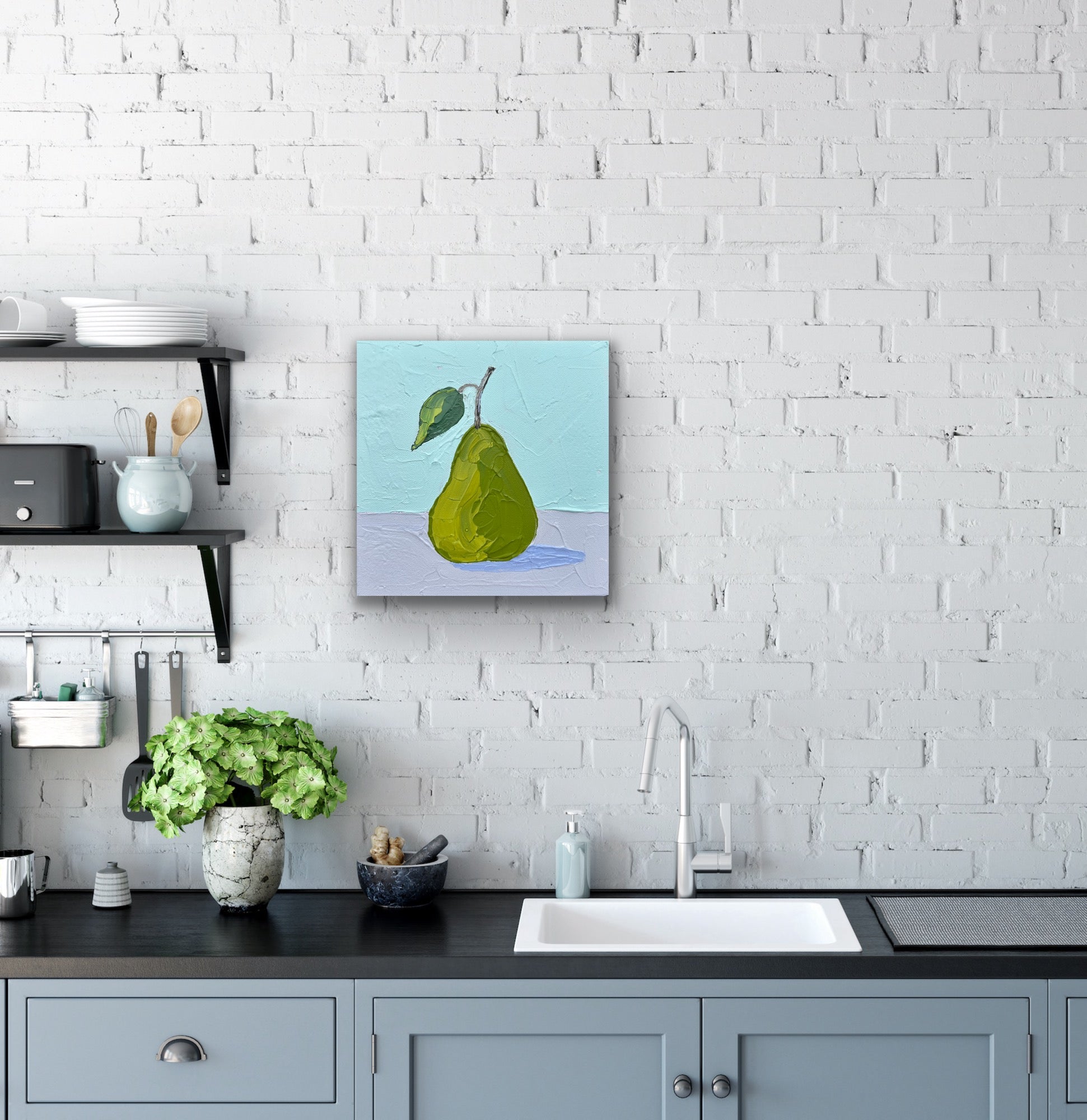 Kitchen with a painting of a green pear on a white brick wall.