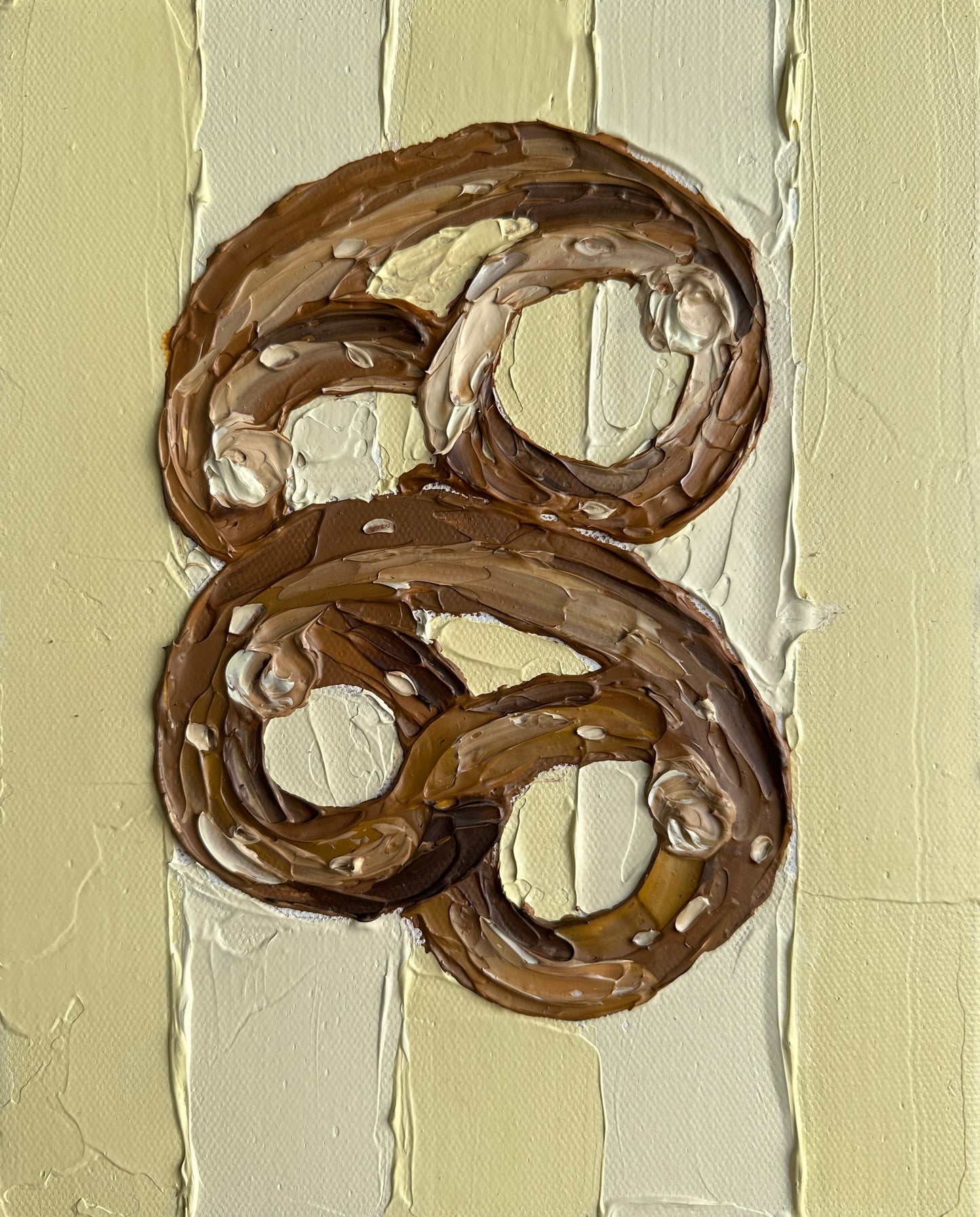 Two chocolate pretzels on a textured beige background