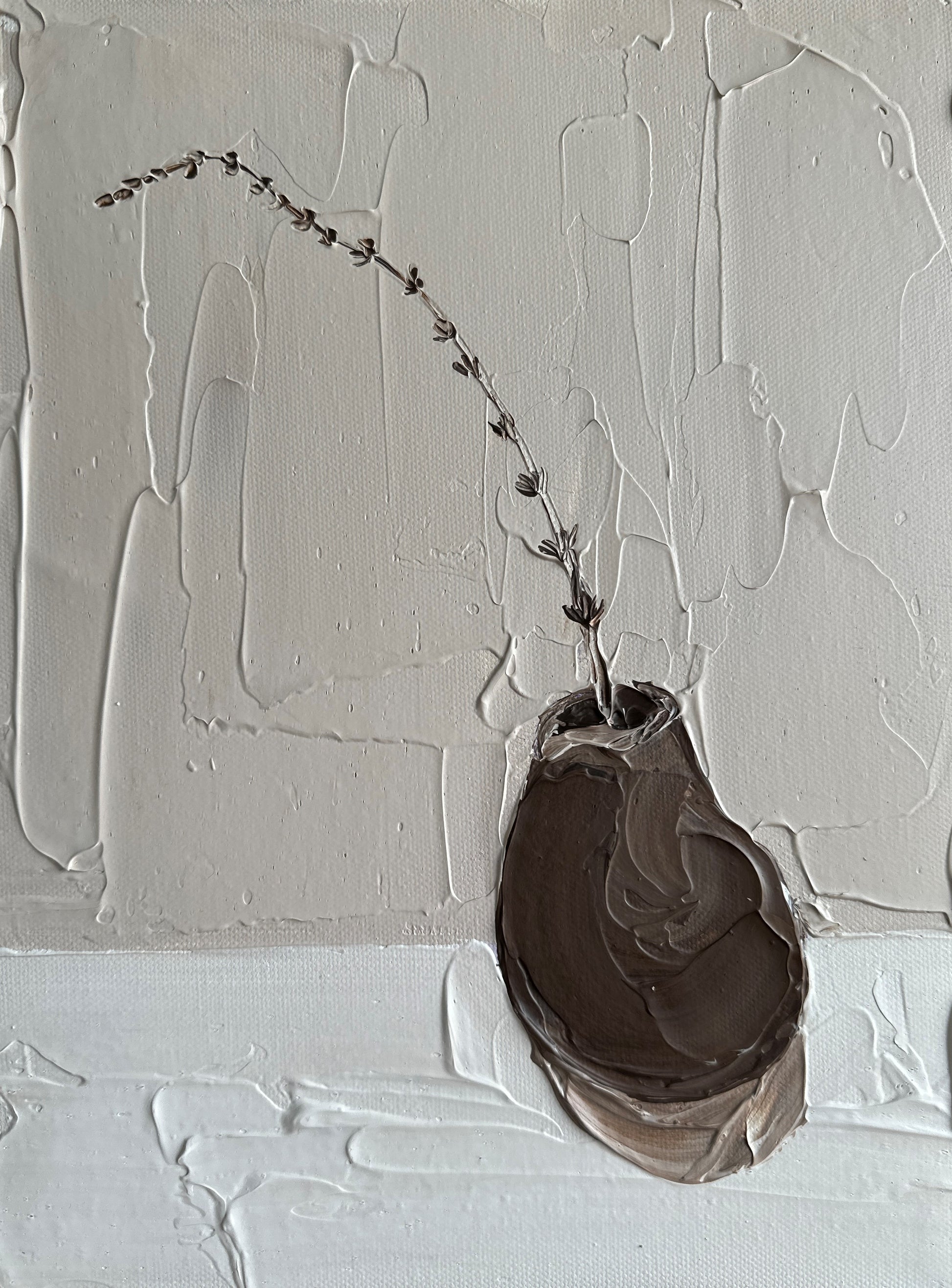 Abstract art piece with a brown oval shape and a thin branch on a textured white background