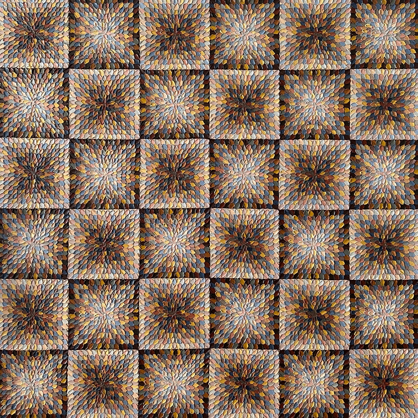 A close-up view of an abstract artwork featuring geometric square patterns in beige and brown tones on a textured background.