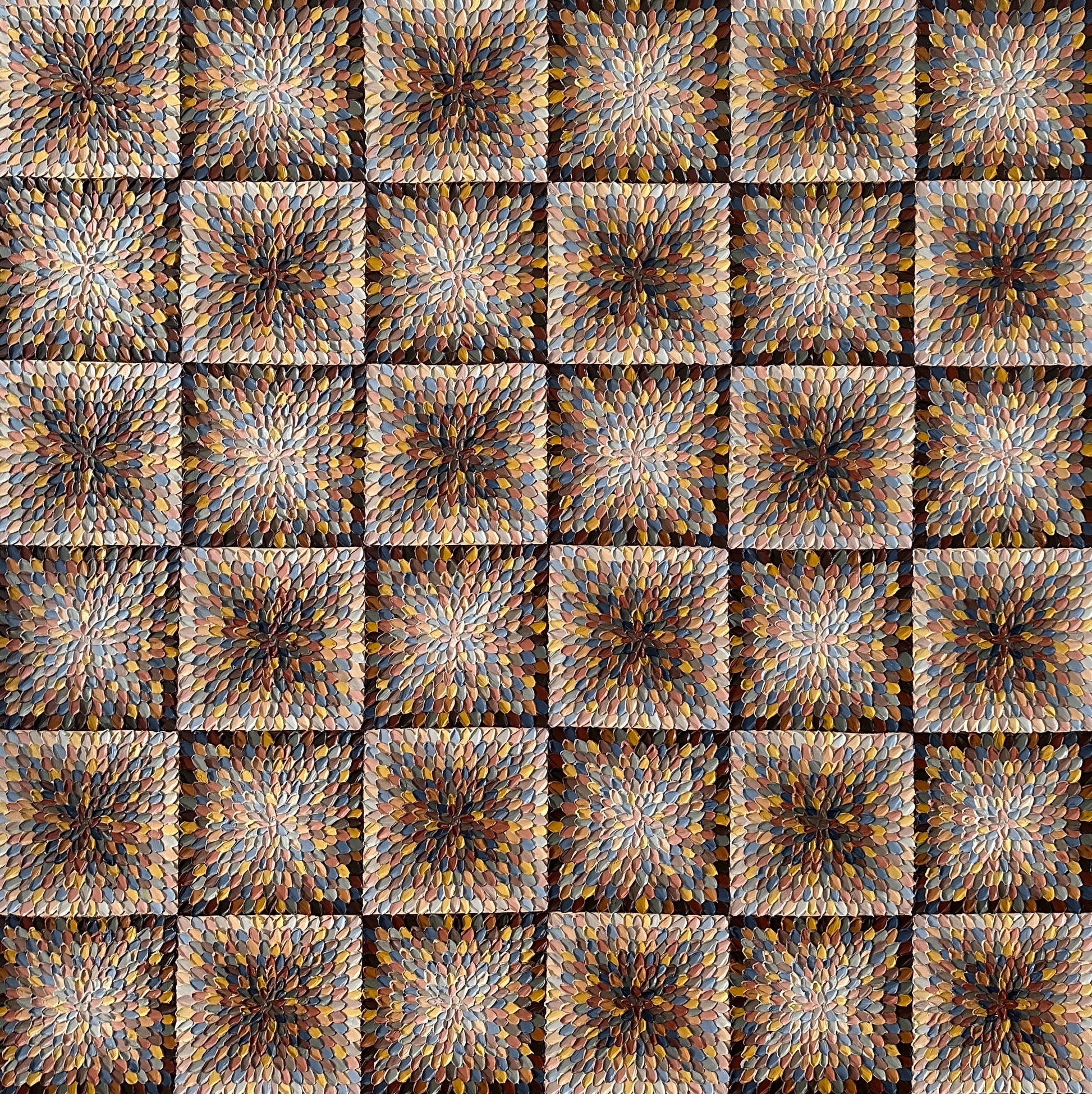 A close-up view of an abstract artwork featuring geometric square patterns in beige and brown tones on a textured background.