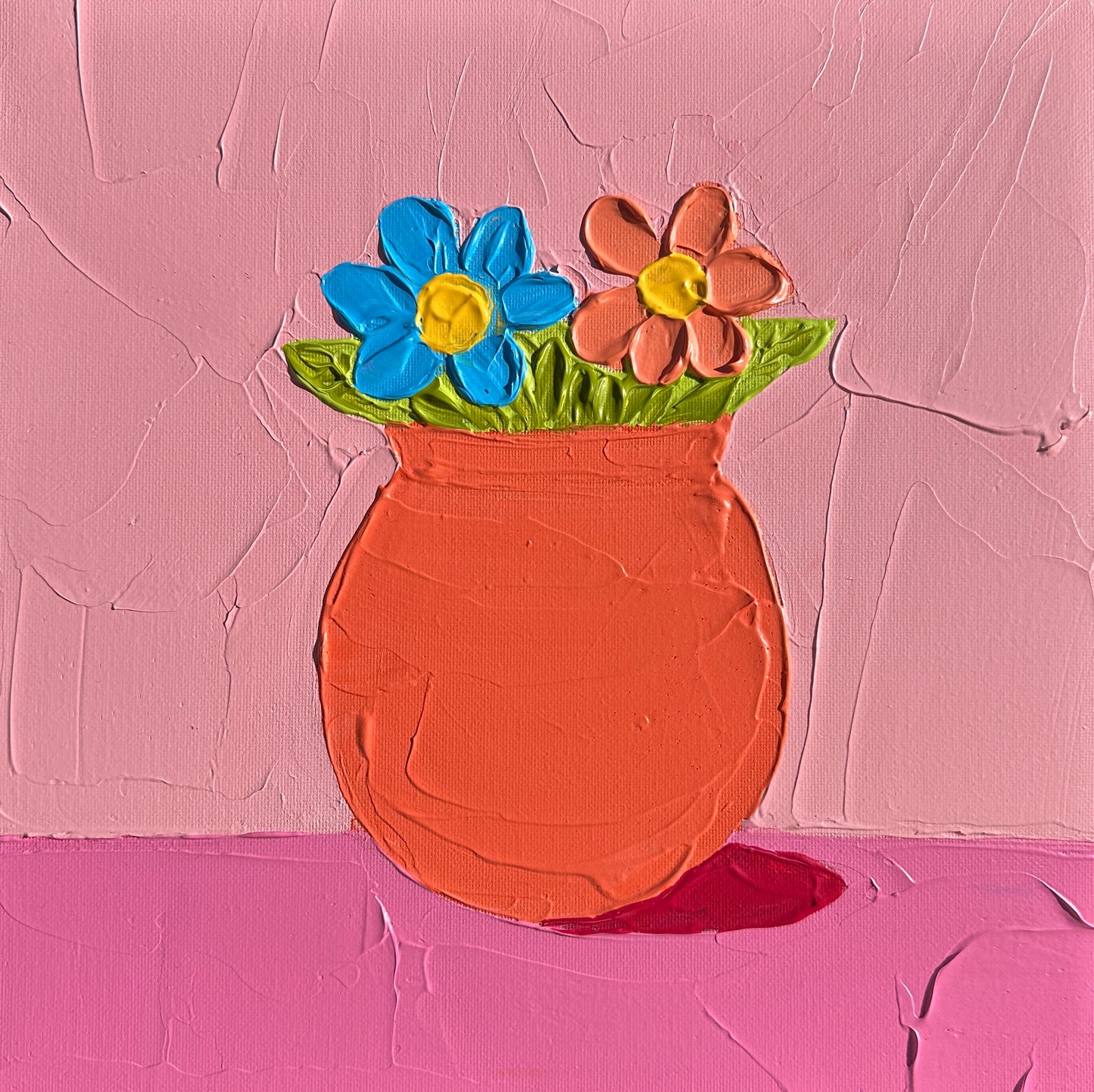Painted ceramic vase with flowers on a textured pink background
